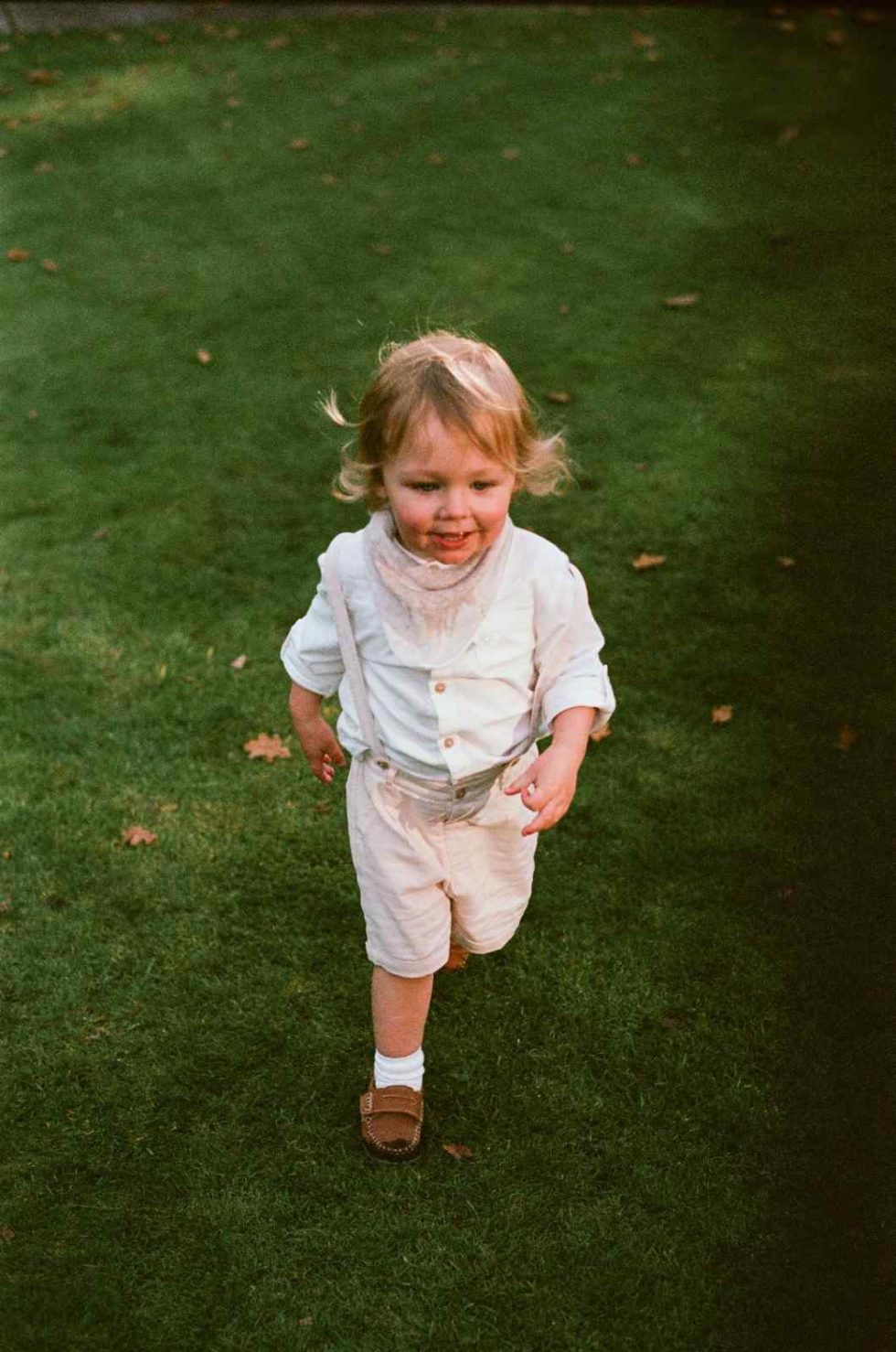 page boy walks on lawn at woodborough hall wedding nottinghamshire