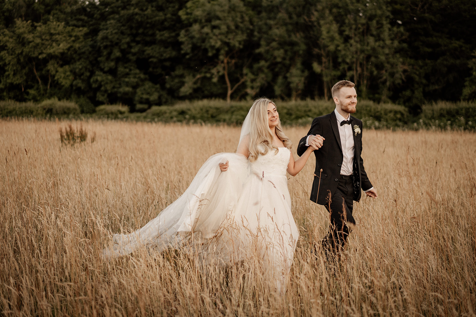 Holly + Peter Bride and groom walking during golden hour at Hazel Gap Barn